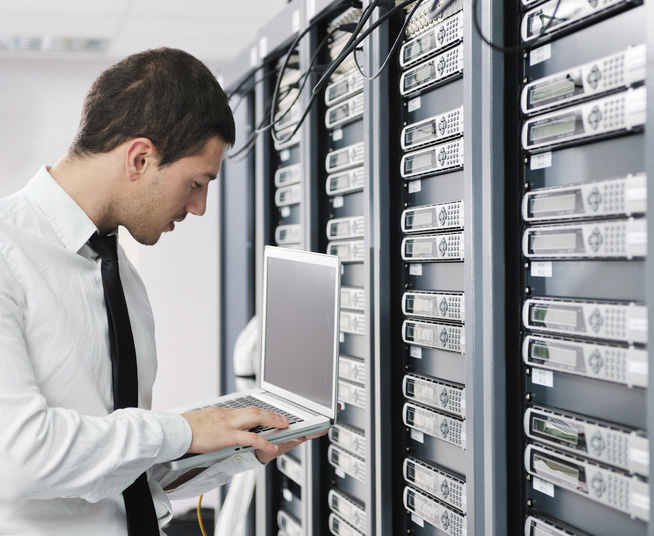 young it  engeneer business man with thin modern aluminium laptop in network server room